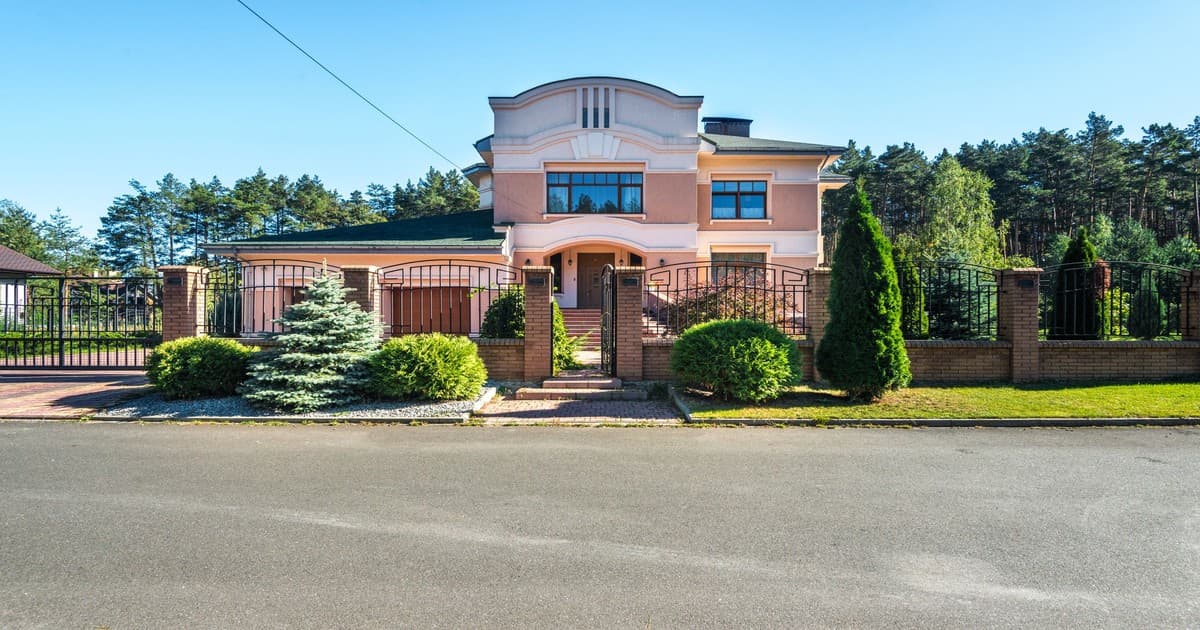 Double-storey gated house with lawn and boundary wall in a Lahore-style suburb