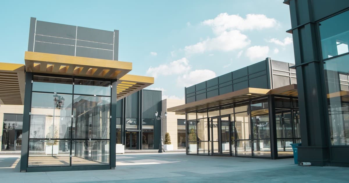 Modern glass-fronted commercial retail stalls in an outdoor shopping plaza