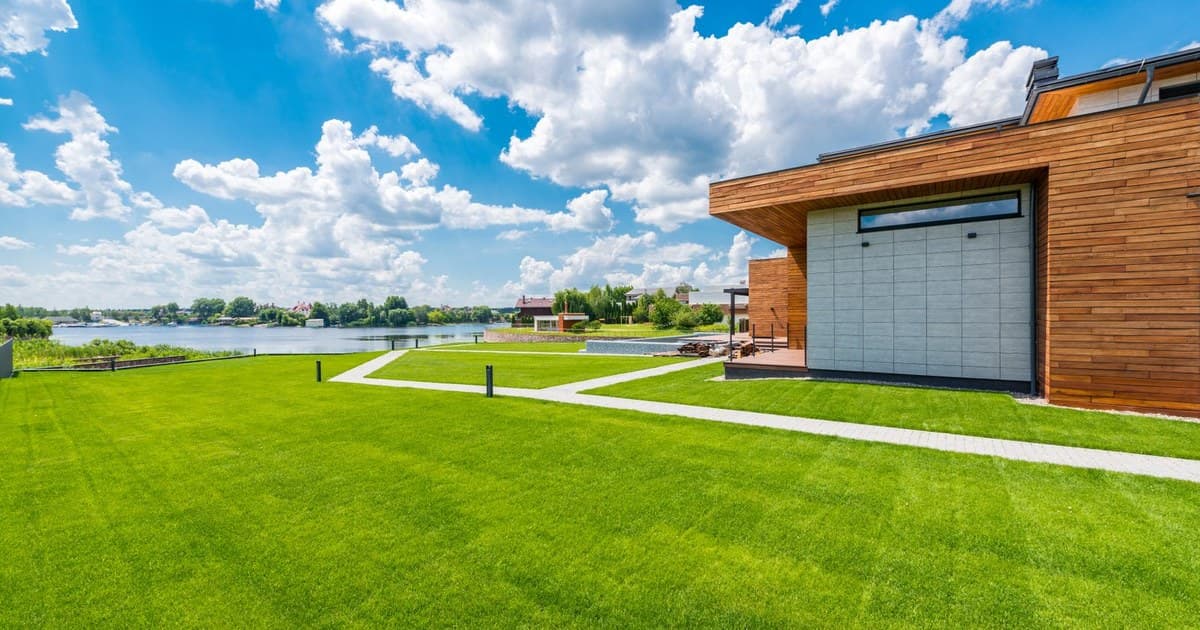 A modern house with a large green lawn in a developed DHA Lahore residential area