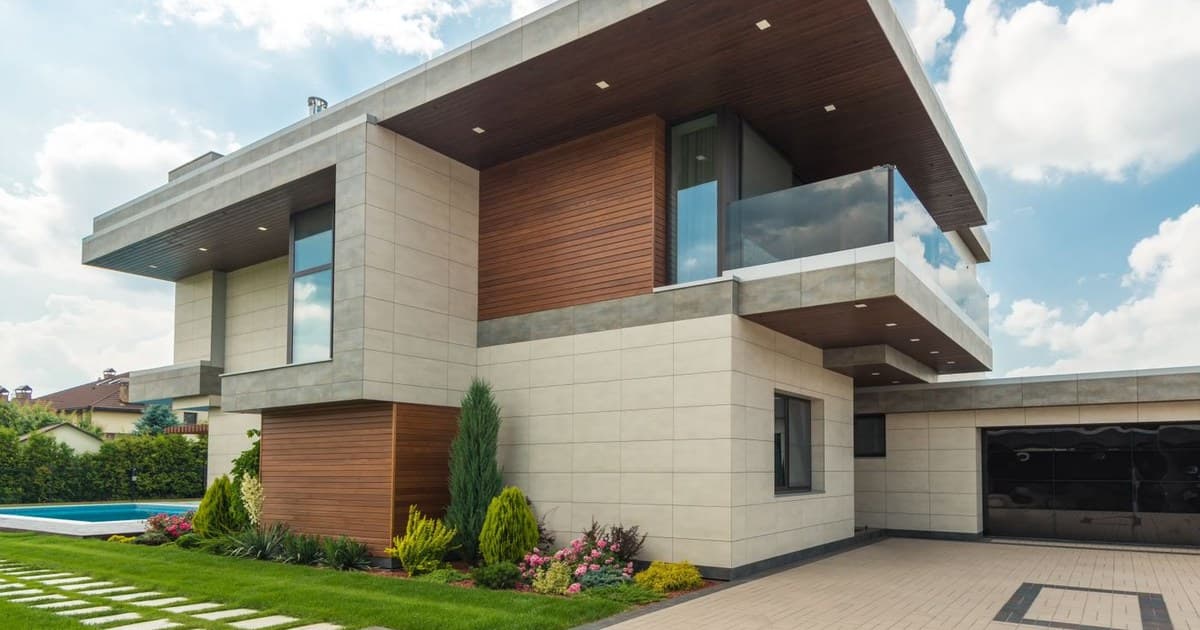Modern house exterior with landscaped lawn and paved driveway