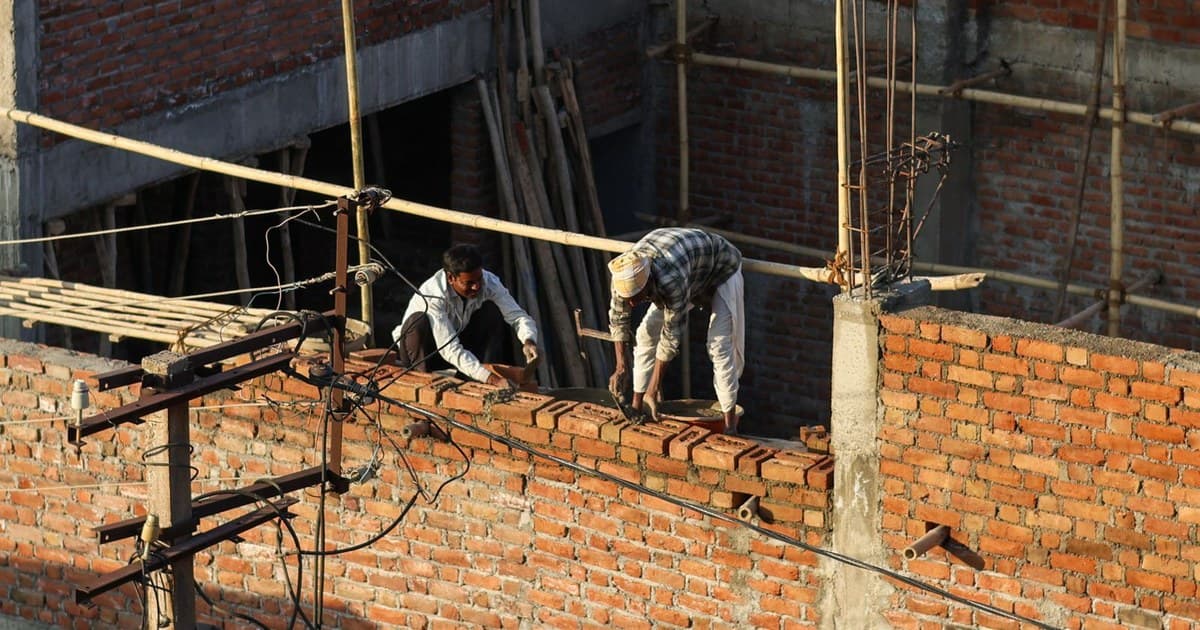 Construction workers laying brick walls on a building site